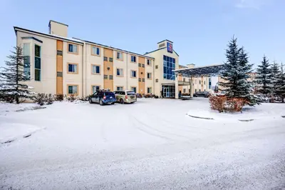 a snow covered parking lot in front of a building at Motel 6-Red Deer, AB in Red Deer