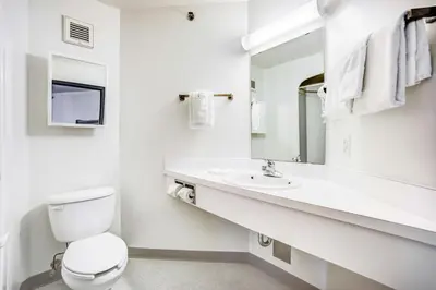 a white bathroom with a toilet and a sink at Motel 6-Red Deer, AB in Red Deer