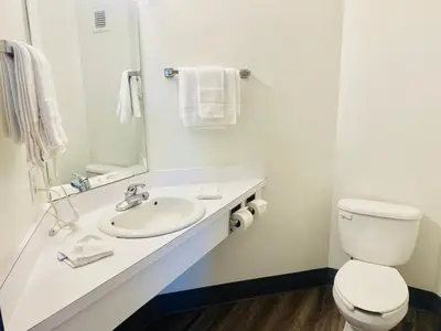 a bathroom with a white toilet and a sink at Motel 6-Red Deer, AB in Red Deer