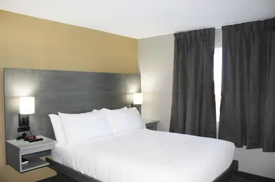 a bedroom with a large white bed and a window at Days Inn by Wyndham Stony Plain in Stony Plain