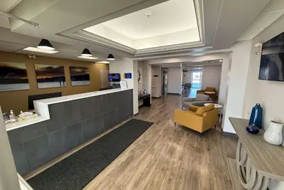 a lobby with a yellow chair and a waiting room at Days Inn by Wyndham Stony Plain in Stony Plain