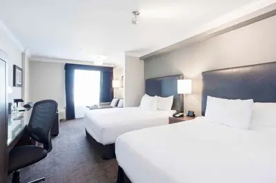 a hotel room with two beds and a chair at Sandman Signature Prince George Hotel in Prince George