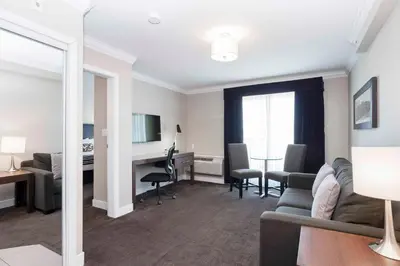 a living room with a couch and a desk at Sandman Signature Prince George Hotel in Prince George