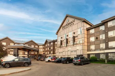 a large building with cars parked in a parking lot at Sandman Signature Edmonton South Hotel in Edmonton