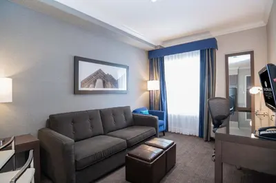 a living room with a couch in a hotel room at Sandman Signature Edmonton South Hotel in Edmonton