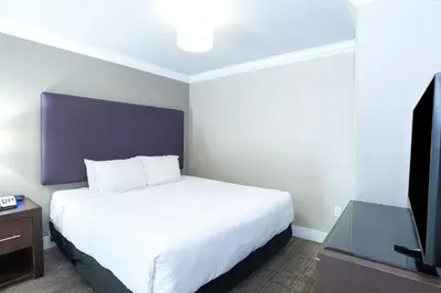a hotel room with a bed and a flat screen tv at Sandman Hotel & Suites Calgary South in Calgary