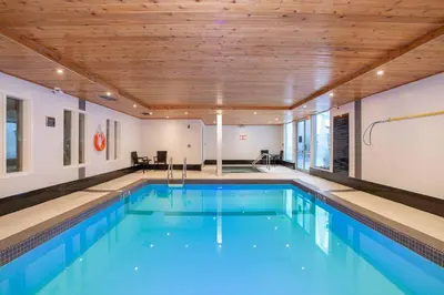 a large swimming pool with a wooden ceiling at Sandman Hotel & Suites Calgary South in Calgary