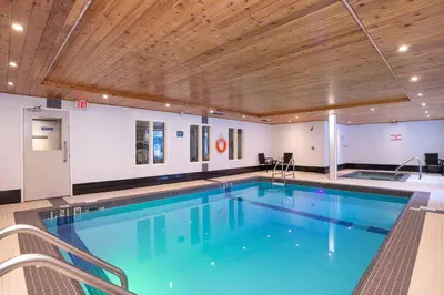 a large swimming pool with a wooden ceiling at Sandman Hotel & Suites Calgary South in Calgary