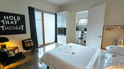a bedroom with a white bed and a window at The Cube Cow Bay Suite in Cowichan Bay
