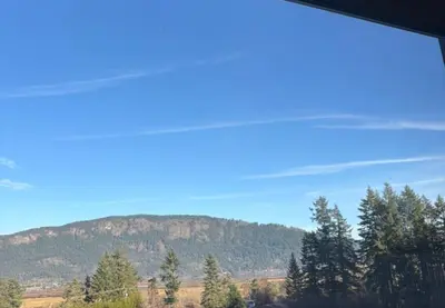 a view of a mountain from a window at The Cube Cow Bay Suite in Cowichan Bay