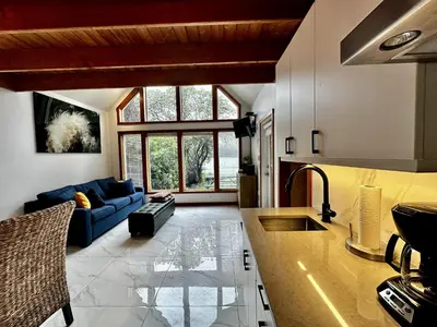 a kitchen and living room with a blue couch at Private Oceanfront Cabin And Hot Tub! - Gww in Ucluelet