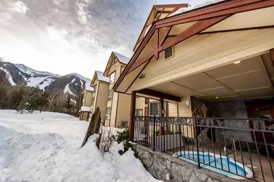 a house in the snow with a balcony at Timberline Lodge by StayIn in Fernie