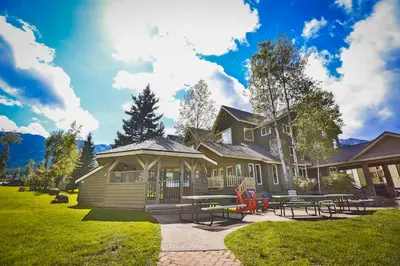 a house with a picnic table in front of it at Timberline Lodge by StayIn in Fernie