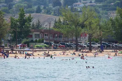 a group of people on a beach in the water at Spanish Villa Resort in Penticton