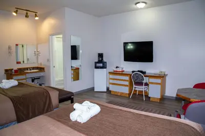 a hotel room with two beds and a television at Spanish Villa Resort in Penticton
