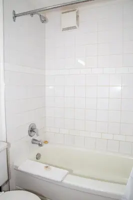 a white bathroom with a tub and a toilet at Spanish Villa Resort in Penticton