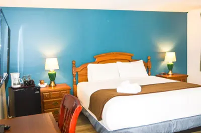 a bedroom with a large bed with a blue wall at Spanish Villa Resort in Penticton