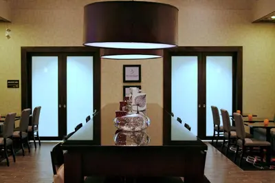 a dining room with a table with wine glasses on it at Hampton Inn & Suites Red Deer in Red Deer