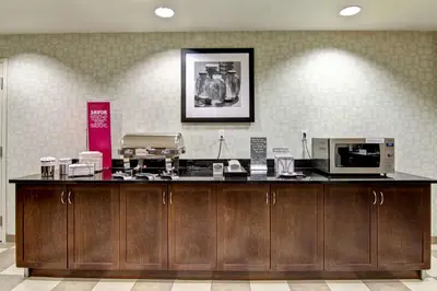 a kitchen with a counter with a microwave and appliances at Hampton Inn & Suites Red Deer in Red Deer