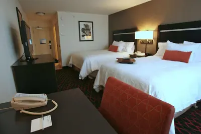 a hotel room with two beds and a phone on a table at Hampton Inn & Suites Red Deer in Red Deer