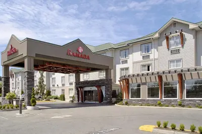 a hotel with a sign on the front of a building at Ramada by Wyndham Surrey/Langley in Surrey