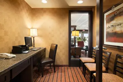 a hotel room with a reception desk and chairs at Ramada by Wyndham Surrey/Langley in Surrey