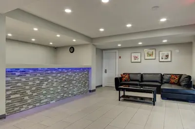 a waiting room with a couch and a brick wall at Knights Inn Kamloops in Kamloops