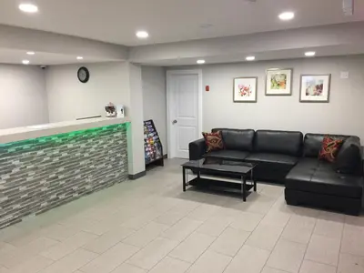 a living room with a black couch and a table at Knights Inn Kamloops in Kamloops