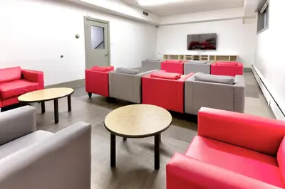 a waiting room with red and white chairs and tables at HI Edmonton - Hostel in Edmonton