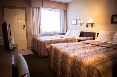 a hotel room with two beds and a window at Langley Hwy Hotel in Langley