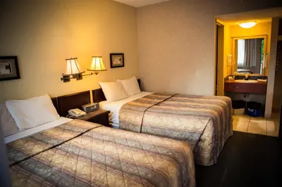 a hotel room with two beds and a window at Langley Hwy Hotel in Langley