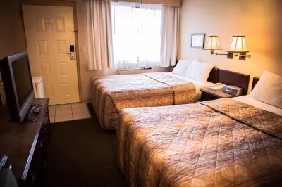 a hotel room with two beds and a television at Langley Hwy Hotel in Langley
