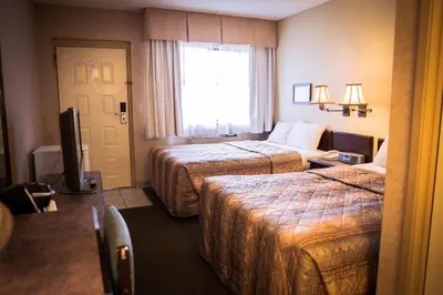 a hotel room with two beds and a window at Langley Hwy Hotel in Langley