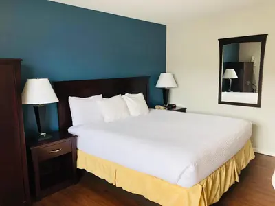 a bedroom with a large white bed with two lamps at Days Inn by Wyndham Kamloops BC in Kamloops