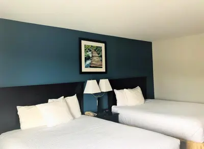 two beds in a hotel room with blue walls at Days Inn by Wyndham Kamloops BC in Kamloops