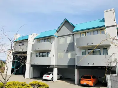 a building with two cars parked in front of it at Days Inn by Wyndham Kamloops BC in Kamloops
