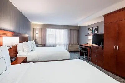 a hotel room with two beds and a desk at Courtyard by Marriott Edmonton West in Edmonton