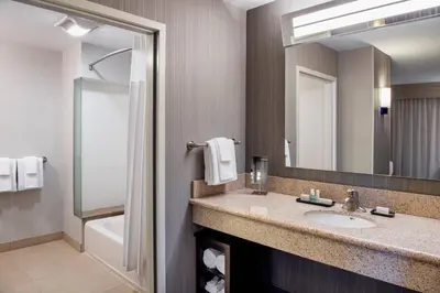 a bathroom with a sink and a mirror at Courtyard by Marriott Edmonton West in Edmonton