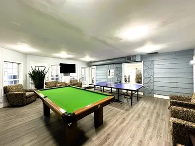 a living room with a pool table and a tv at Okanagan Seasons Resort in Kelowna