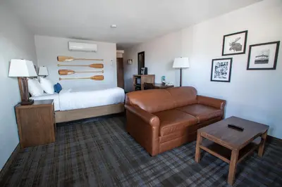 a hotel room with a bed and a couch and a chair at Pyramid Lake Lodge in Jasper