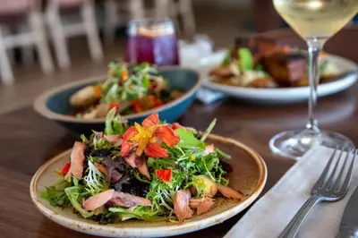 a table with plates of food and a glass of wine at The Crimson Jasper in Jasper