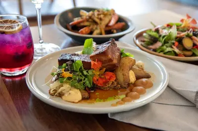 a table with plates of food and a drink at The Crimson Jasper in Jasper