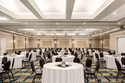 a banquet hall with white tables and chairs at Royal Hotel Edmonton Airport Trademark Collection By Wyndham in Leduc