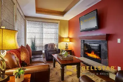 a living room with a tv and a fireplace at Bellstar Suites at Solara Resort in Canmore