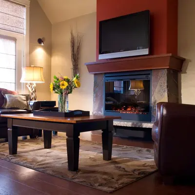 a living room with a fireplace with a tv above it at Bellstar Suites at Solara Resort in Canmore