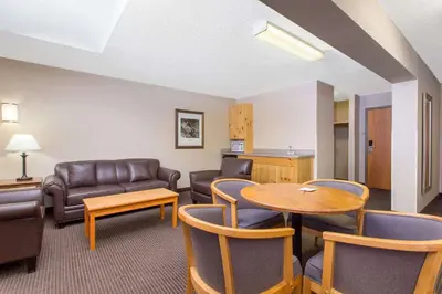 a living room with a couch and a table and chairs at Canmore Inn & Suites in Canmore
