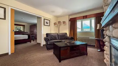 a living room with a couch and a chair in a hotel room at Canmore Inn & Suites in Canmore