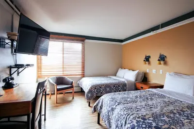 a hotel room with two beds and a desk at Astoria Hotel in Jasper
