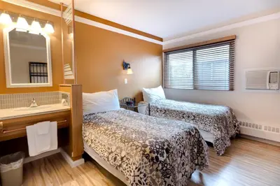 a hotel room with two beds and a sink at Astoria Hotel in Jasper