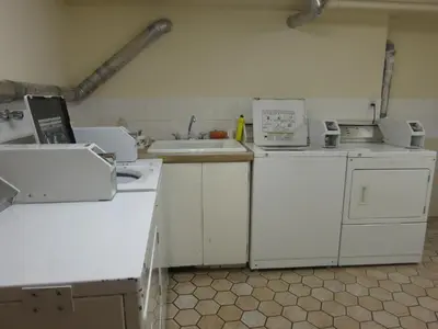 a kitchen with white appliances and a sink at Tropicana Suite Hotel in Vancouver